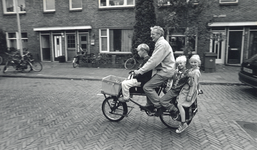 405291 Afbeelding van vader Frans den Otter op een transportfiets met zijn kinderen Auke (9, voorop) en de tweeling ...